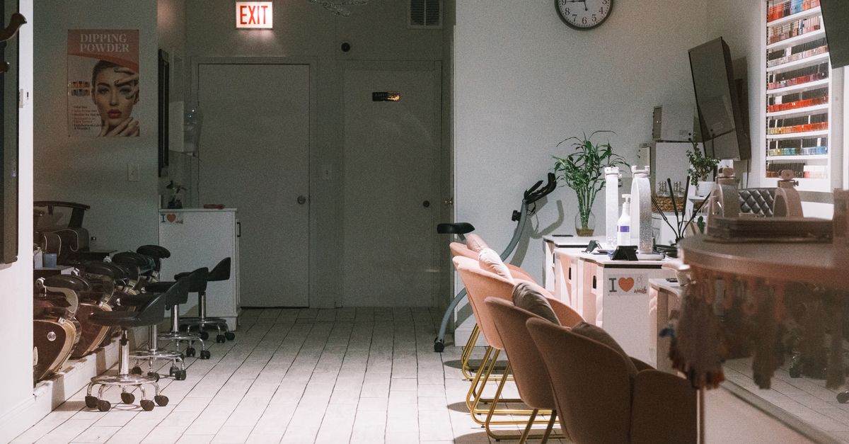 A cozy and modern nail salon interior featuring stylish chairs and nail polish display.